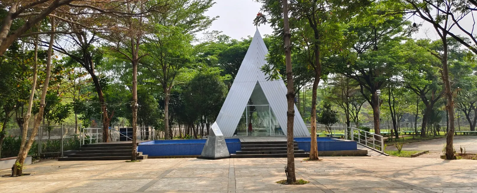 Chapel LWJ berbentuk segitiga putih di tengah pelataran berpohon