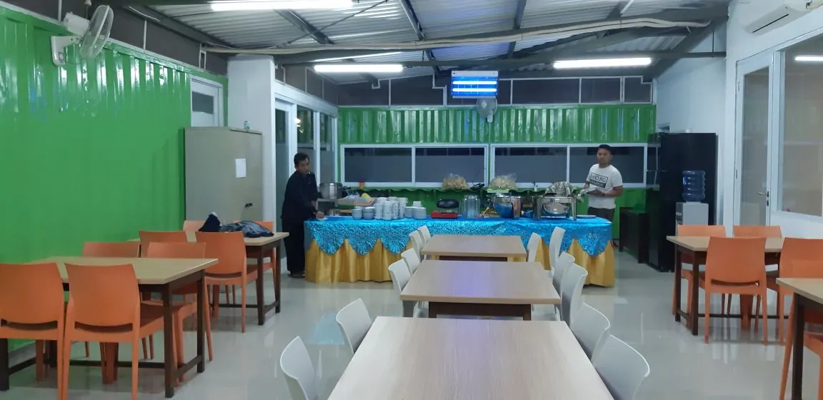 Ruang makan dengan meja prasmanan dan kursi oranye