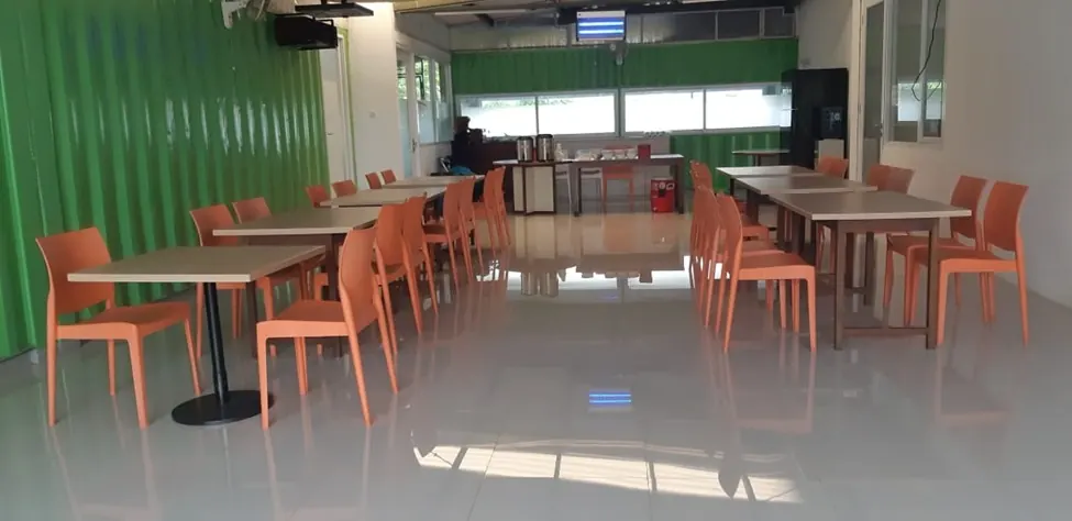 Ruang makan dengan meja kayu dan kursi oranye