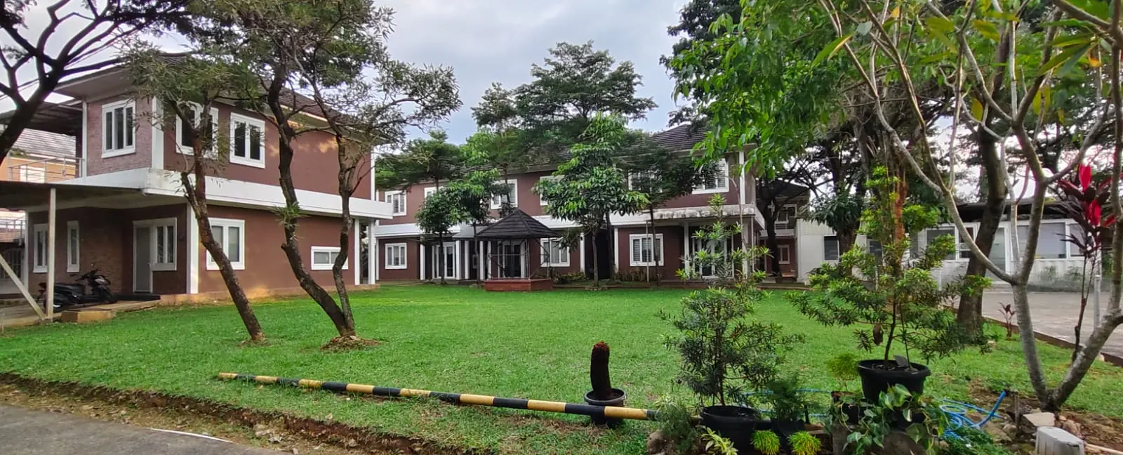 Deretan rumah penginapan dua lantai dengan halaman berumput