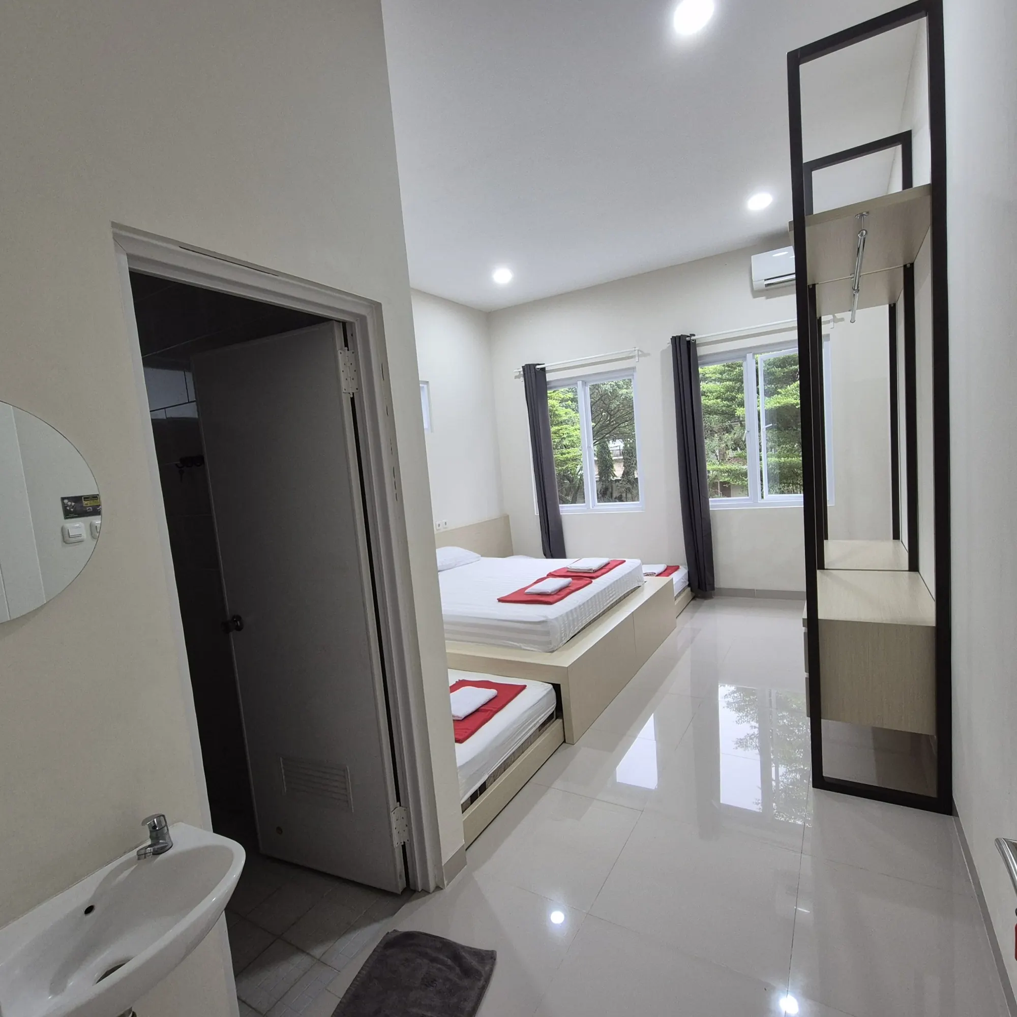 Kamar tidur rumah penginapan dengan pintu kamar mandi dan cermin